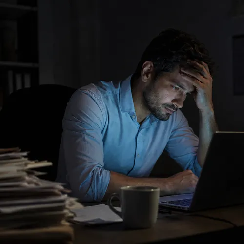 Empresário cansado lendo edital de madrugada no escritório
